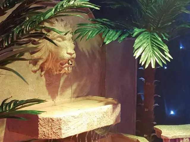 Themed decor with palm trees and a sculpted wall