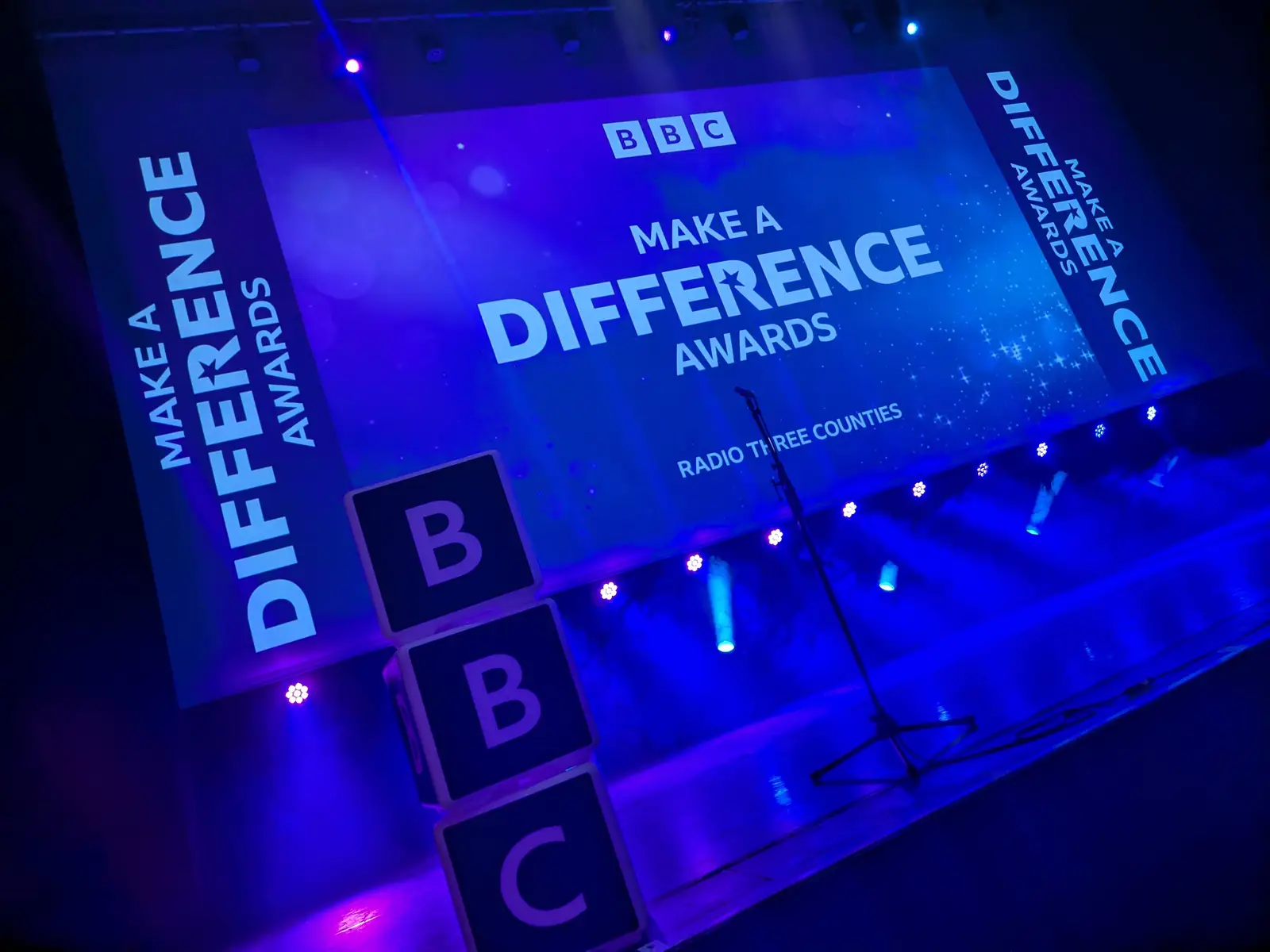 BBC Make a Difference Awards stage for BBC Radio Three Counties, with BBC letter cubes, blue lighting and a branded screen